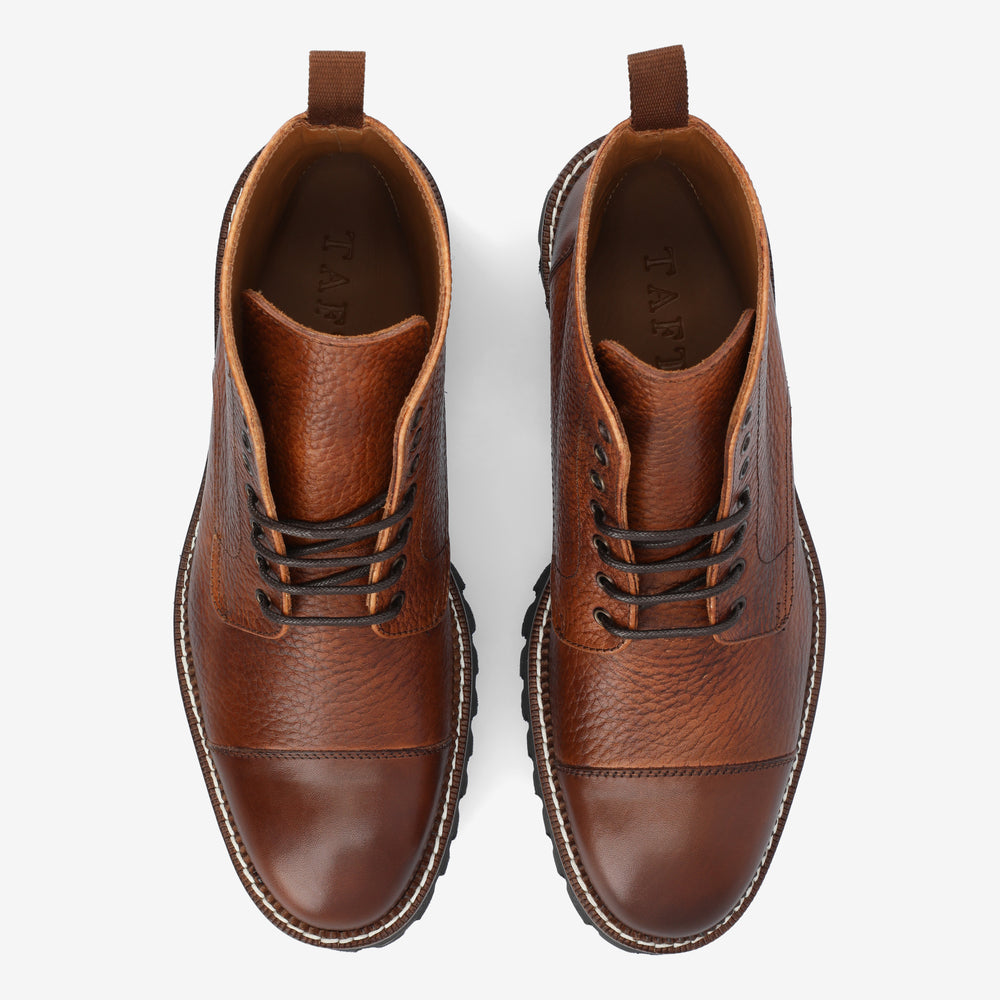 Top view of a pair of brown leather lace-up boots with textured and smooth sections, brown pull tabs, and stitched soles on a white background.
