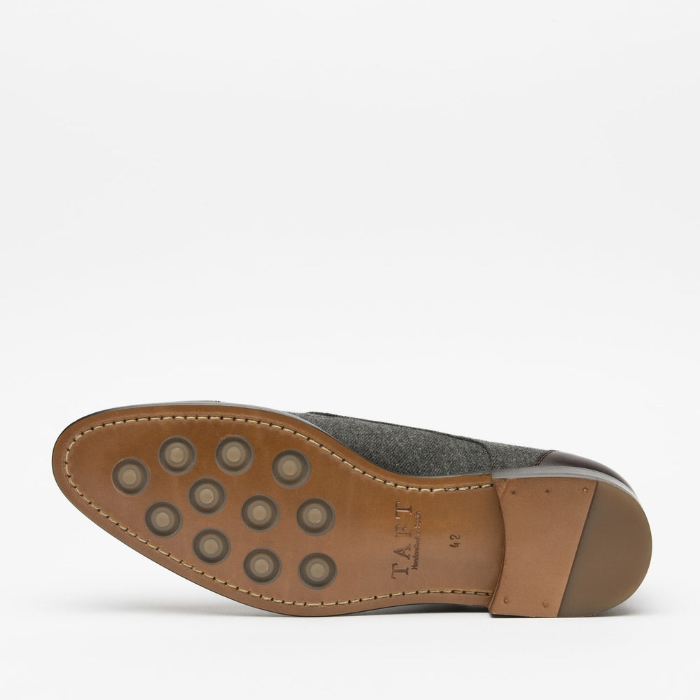 Sole of a shoe displaying a brown leather sole with circular grip patterns, a wooden heel, and the brand name TAFT stamped on the arch area.