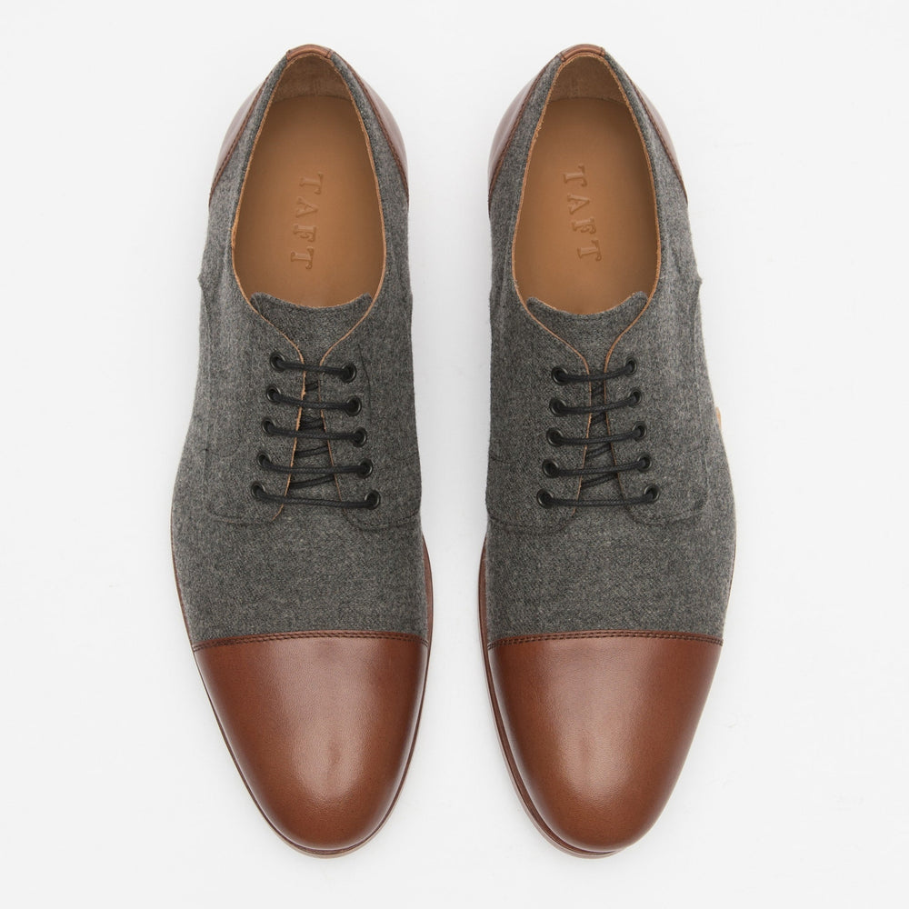 A pair of men's dress shoes with gray fabric uppers and brown leather toe caps and trim, laced with black shoelaces, viewed from above on a white background.