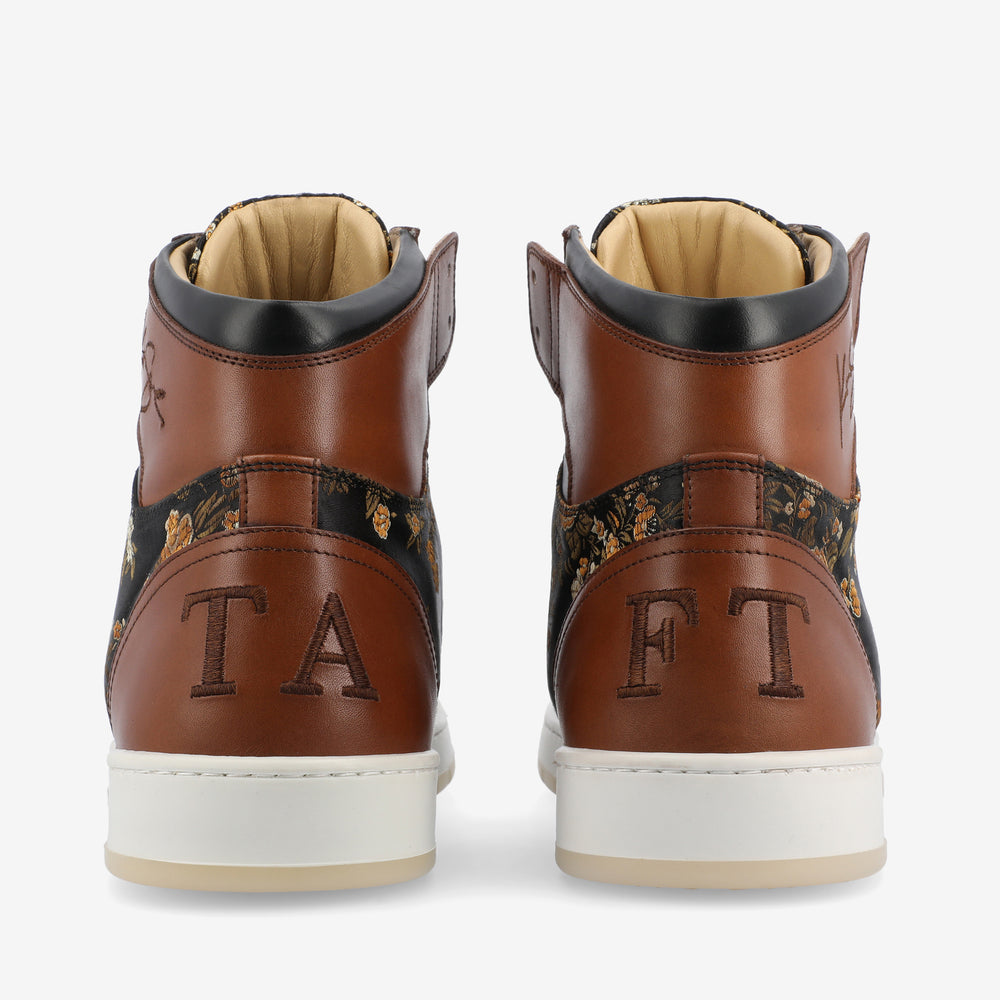 Rear view of brown and black high-top sneakers with floral patterns and initials TA on the left shoe and FT on the right shoe, both displayed on a white background.