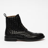 A black leather boot with a woven pattern and brogue detailing, featuring lace-up closure and a pull tab at the heel.