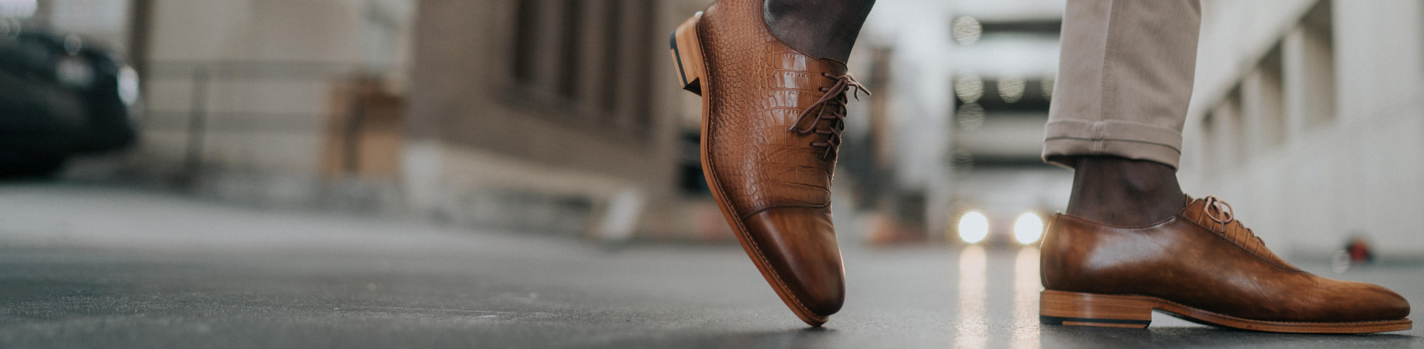 Photo of model ankle down, walking in street, building and scenery behind blurred out, wearing the Paris Honey croc embossed shoes