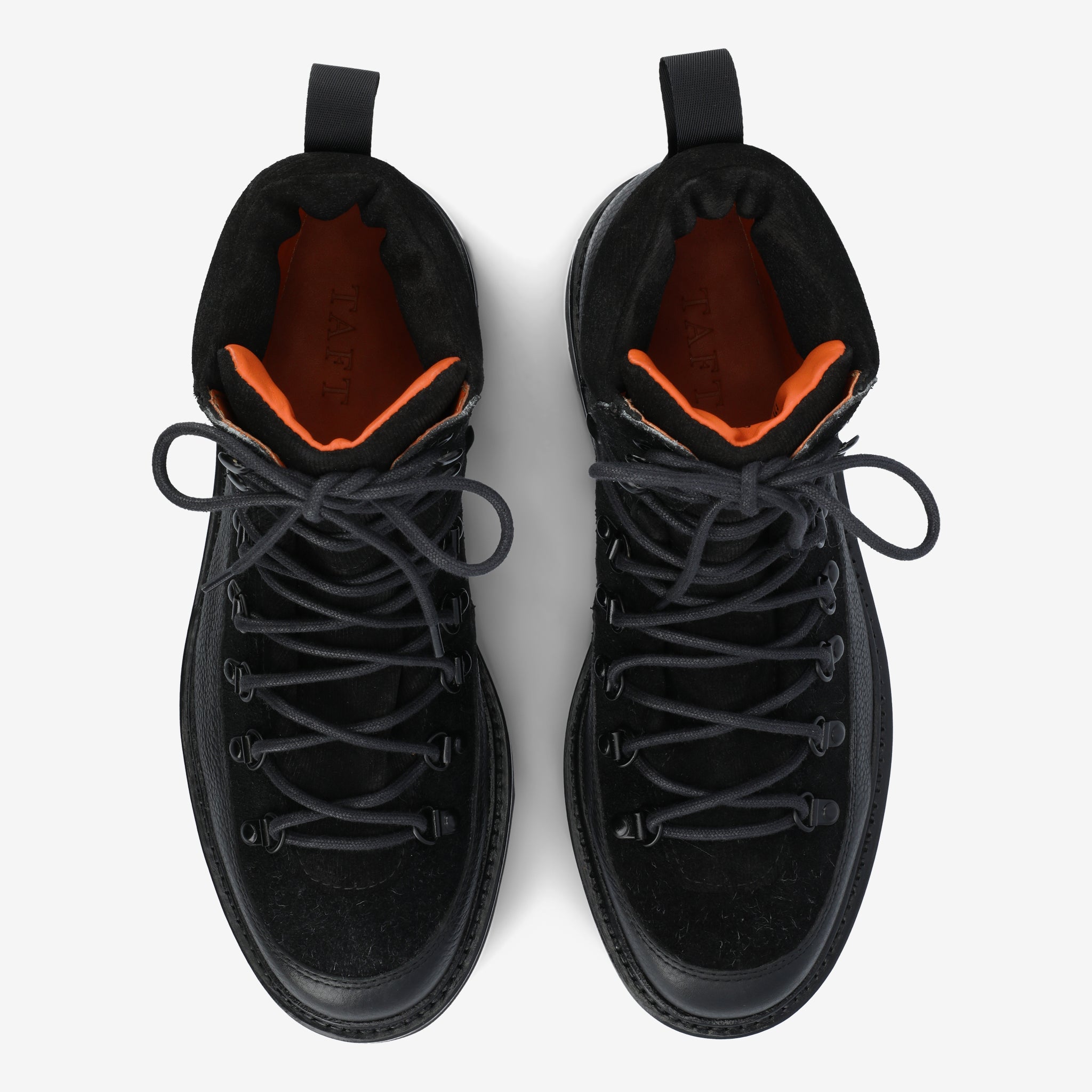 A pair of black hiking boots with black laces and orange inner lining, viewed from above on a white background.