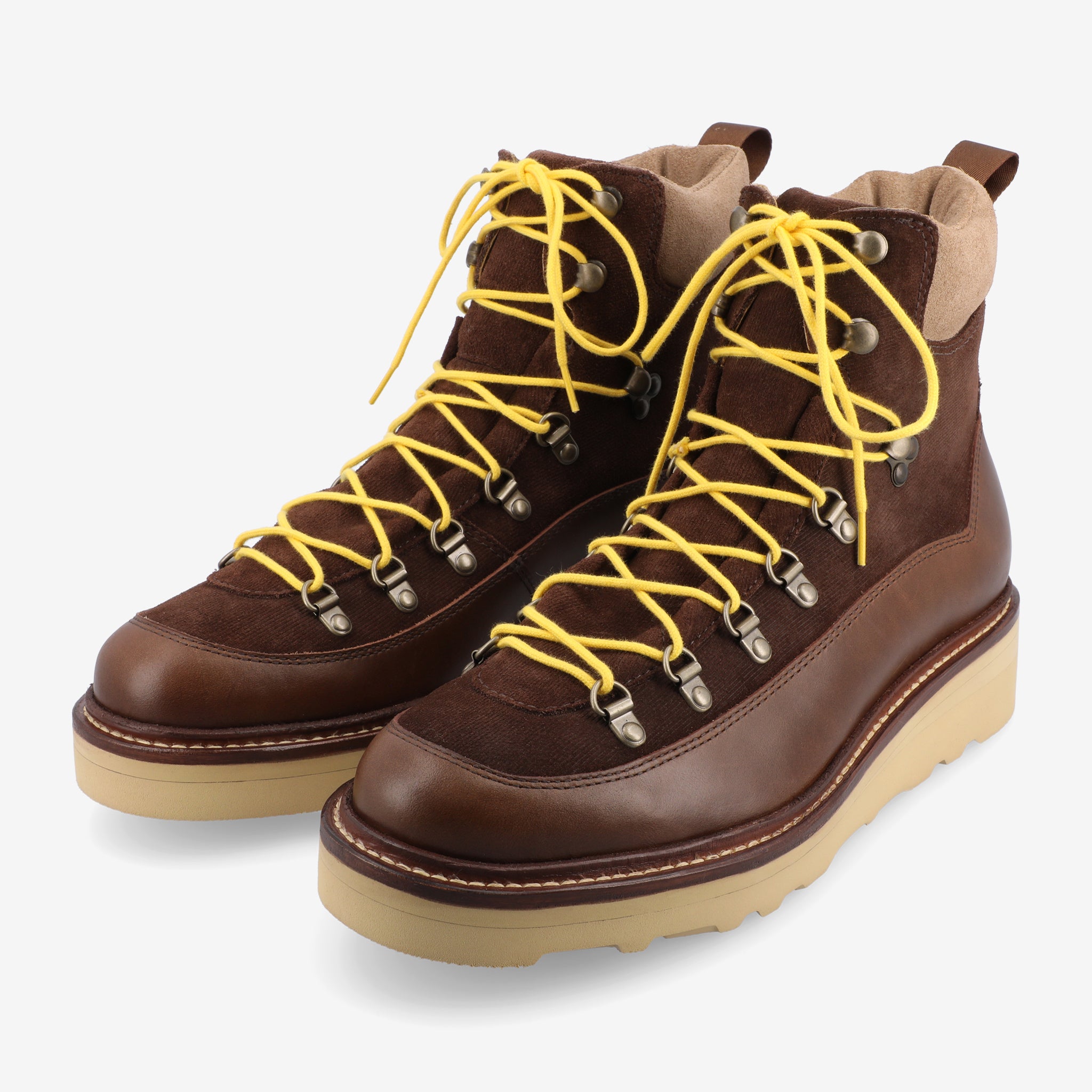 Two brown leather hiking boots with yellow laces and tan rubber soles, positioned side by side on a white background.