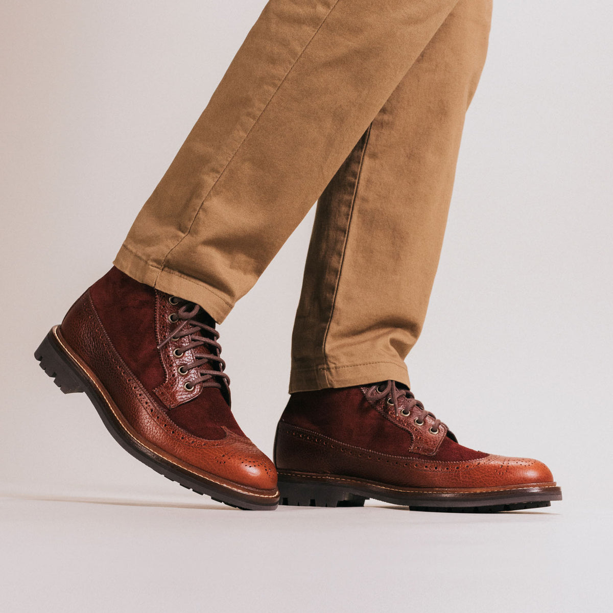 Person wearing tan pants and red-brown leather brogue boots with thick soles.