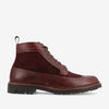 A brown leather and suede lace-up ankle boot with brogue detailing and a rugged sole.