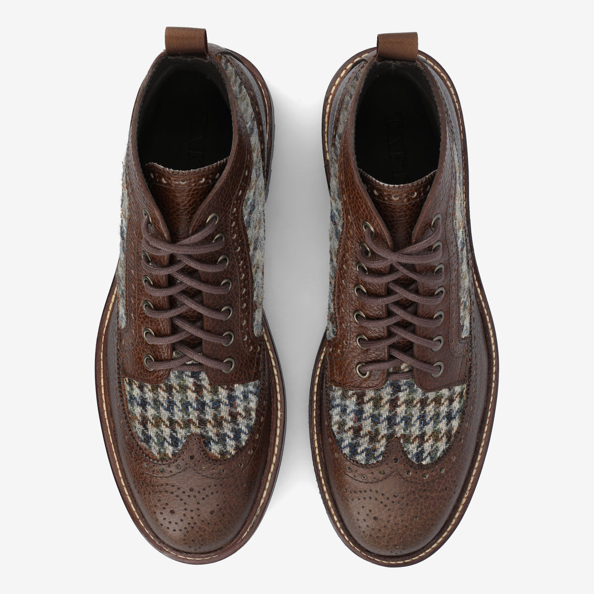 A pair of brown leather brogue boots with detailed stitching and tweed fabric panels, viewed from above.