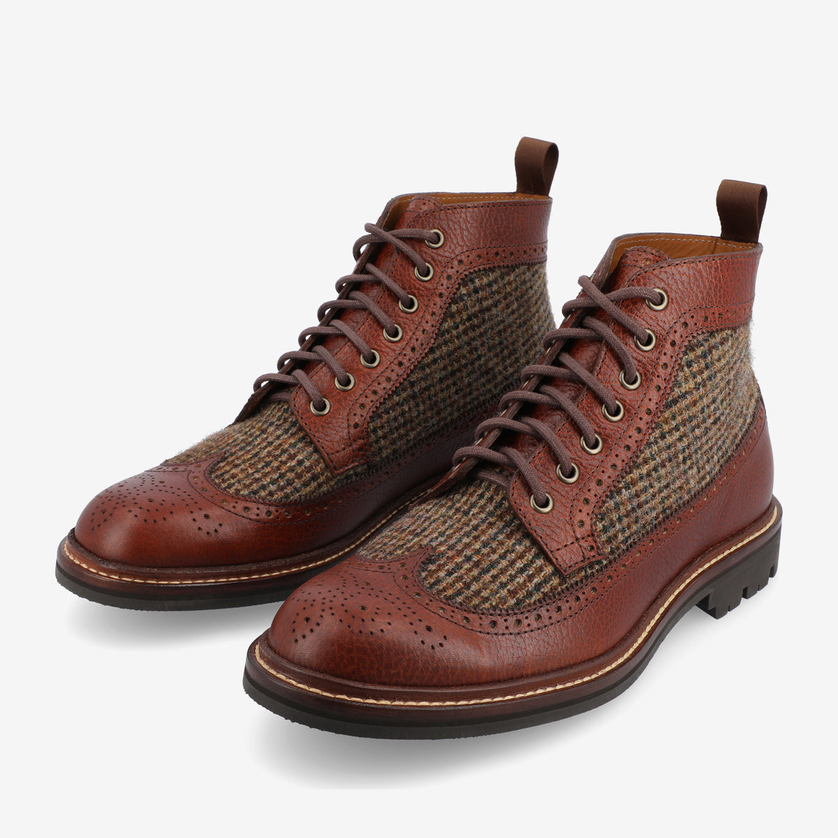 A pair of brown leather brogue boots with herringbone fabric panels and lace-up closure, placed on a plain white background.