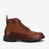 A brown leather and suede wingtip boot with brogue detailing, greenish laces, a loop for easy pull-on, and a rubber sole.