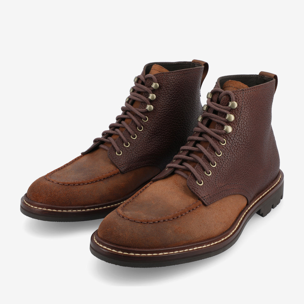 A pair of brown leather lace-up ankle boots with pebbled texture, metal eyelets, and rugged soles.