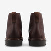 Brown leather ankle boots viewed from the back, featuring textured material and dark brown rubber soles.