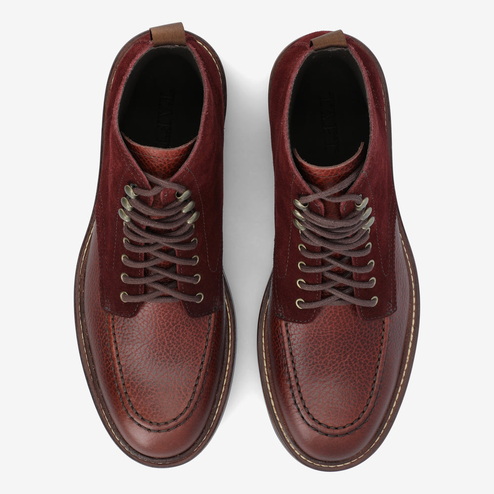 Top view of a pair of brown leather lace-up boots with textured detailing, sitting on a white background.