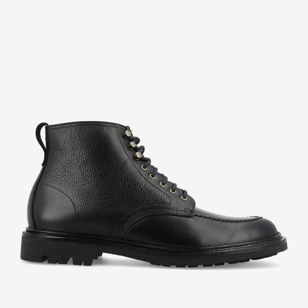 A black leather boot with a rugged sole, lace-up closure, and a pull tab at the heel, viewed from the side.