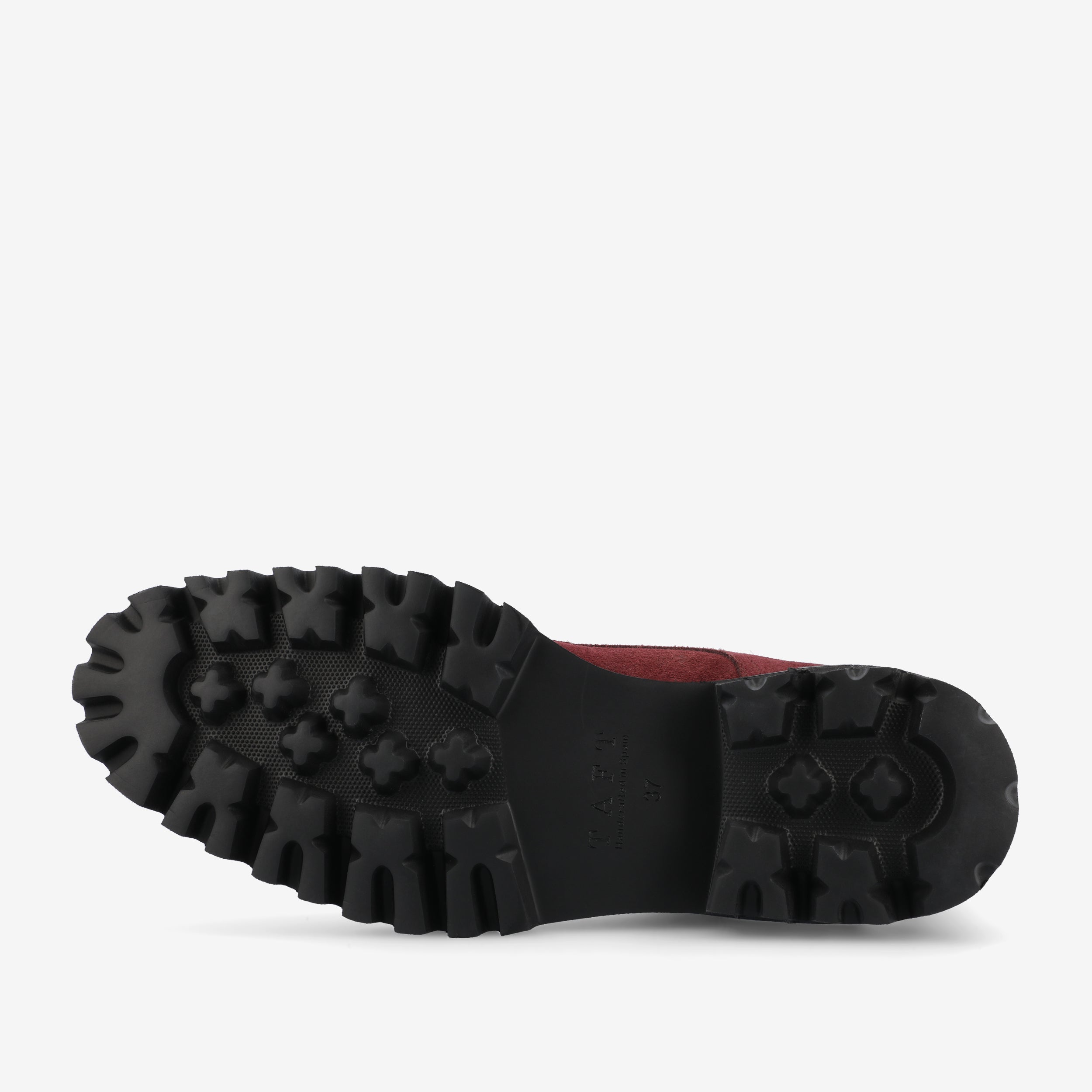 The image shows the sole of a shoe, featuring deep treads designed for traction. The tread design includes various geometric patterns, and the sole is black in color.