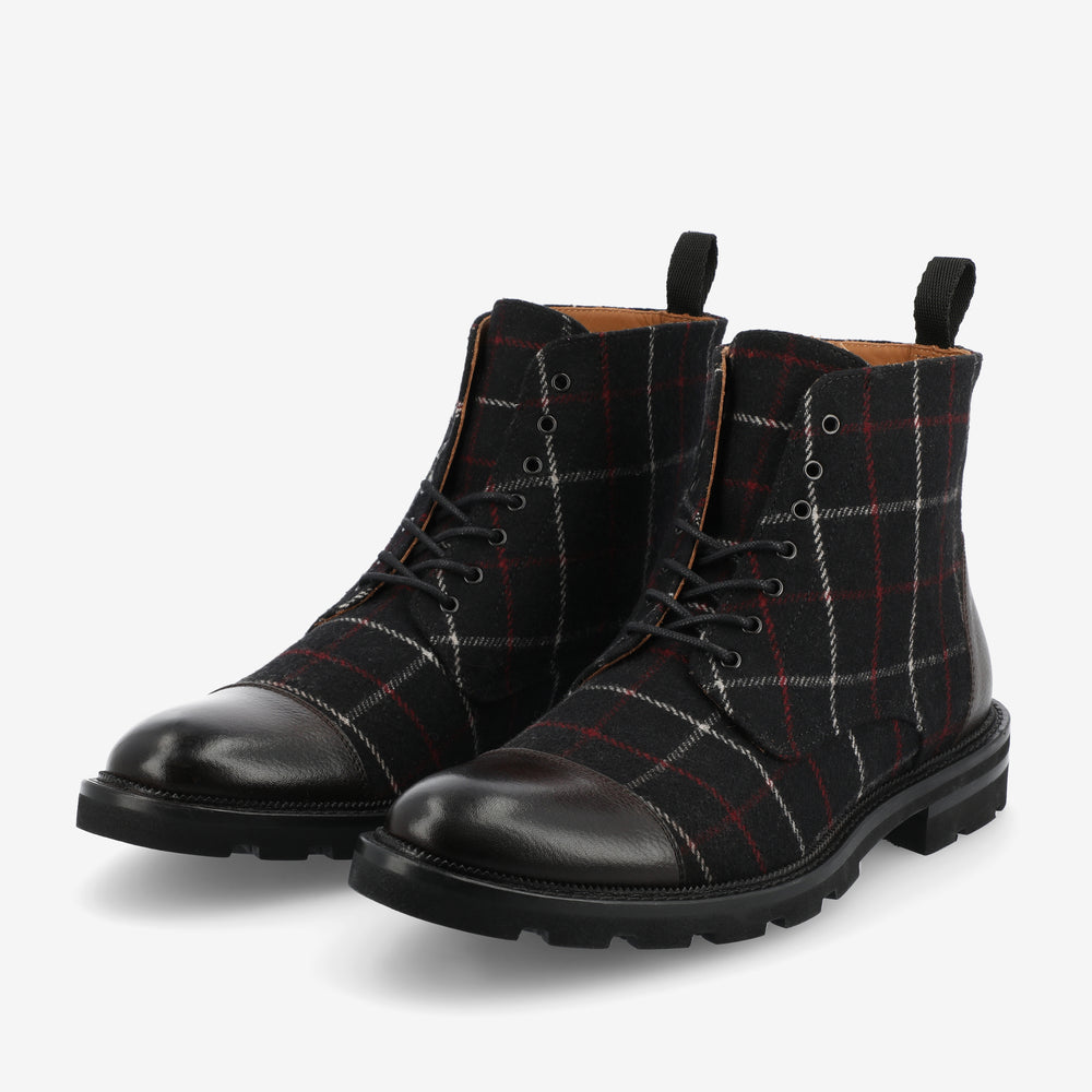 Pair of plaid-patterned boots with black leather toe and heel, black laces, and black rubber soles on a white background.