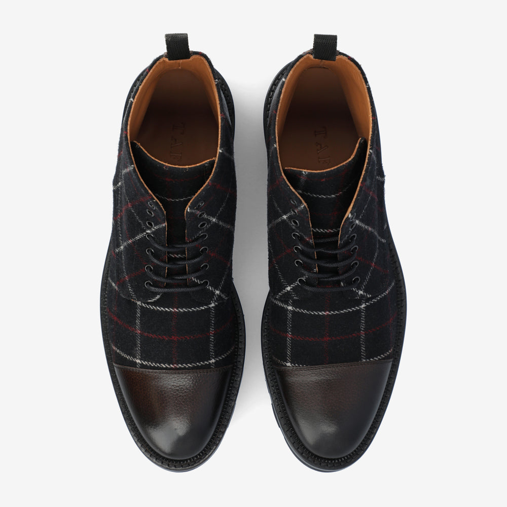 A pair of black leather and plaid lace-up shoes with a checkered pattern, viewed from above.