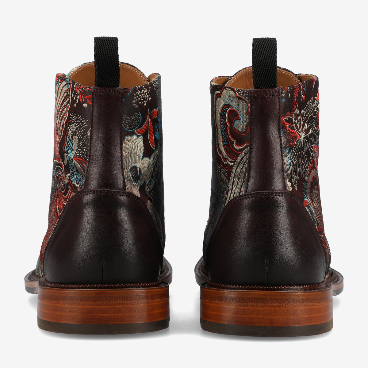 A pair of leather boots with wooden soles and colorful embroidered patterns viewed from the back.