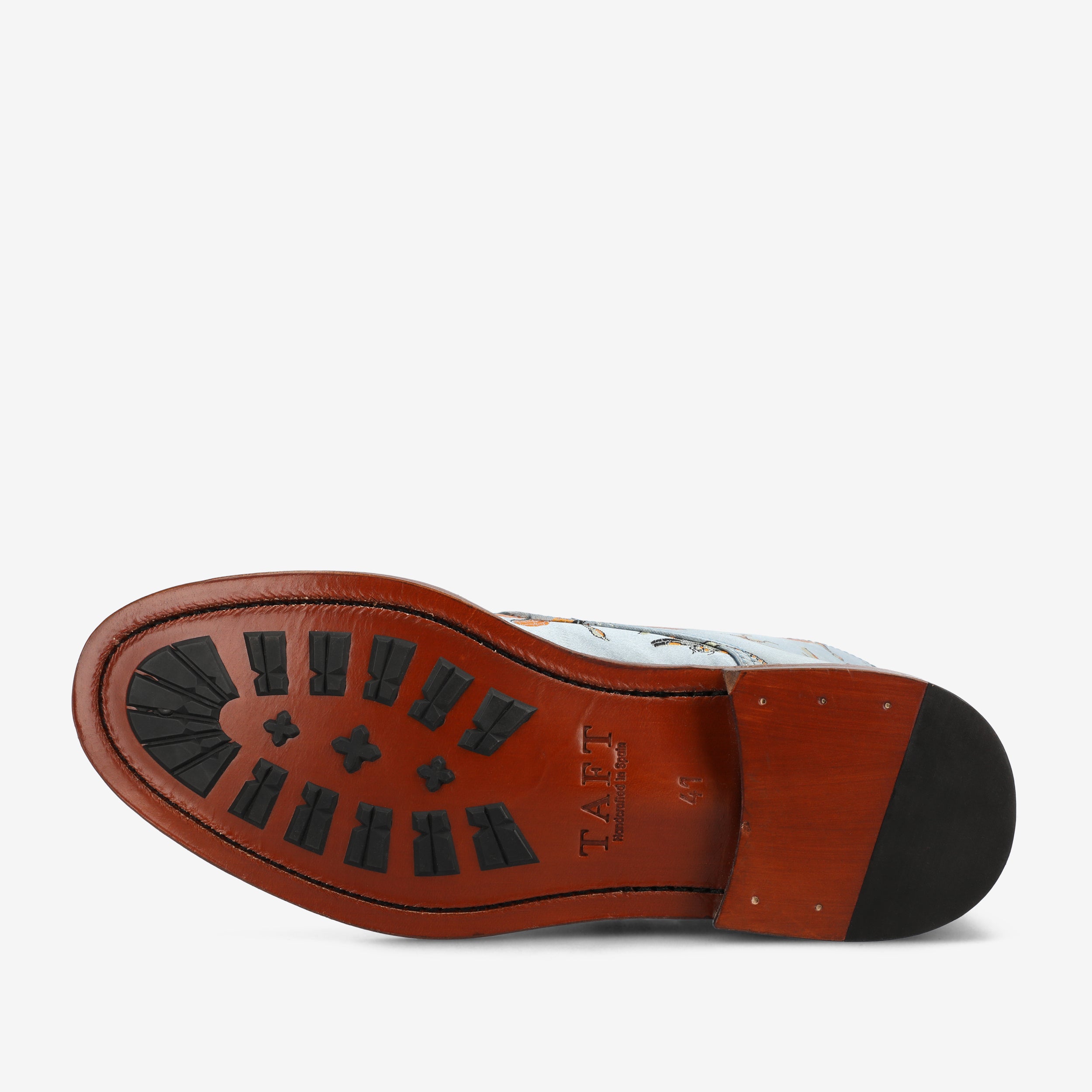 The sole of a shoe with a brown leather base, black rubber grip treads, and TAFT branded text.