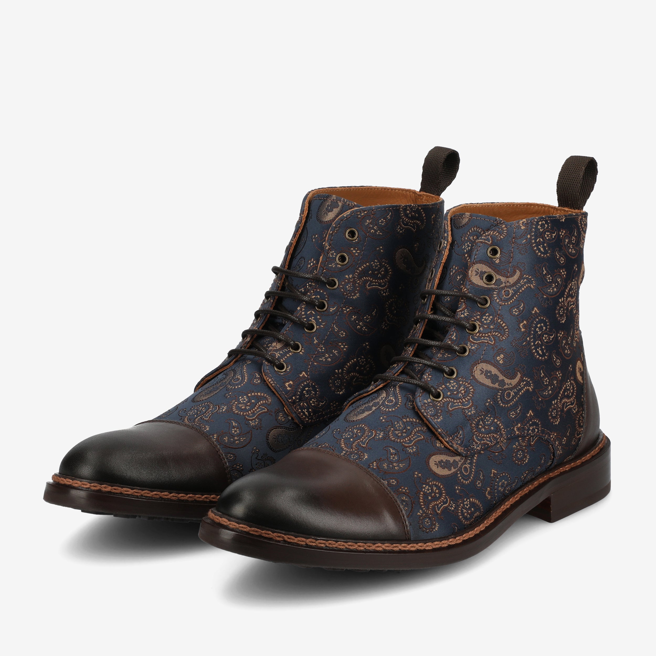 A pair of blue and brown patterned lace-up boots with dark brown toe caps, brown soles, and pull tabs at the heels, displayed against a white background.