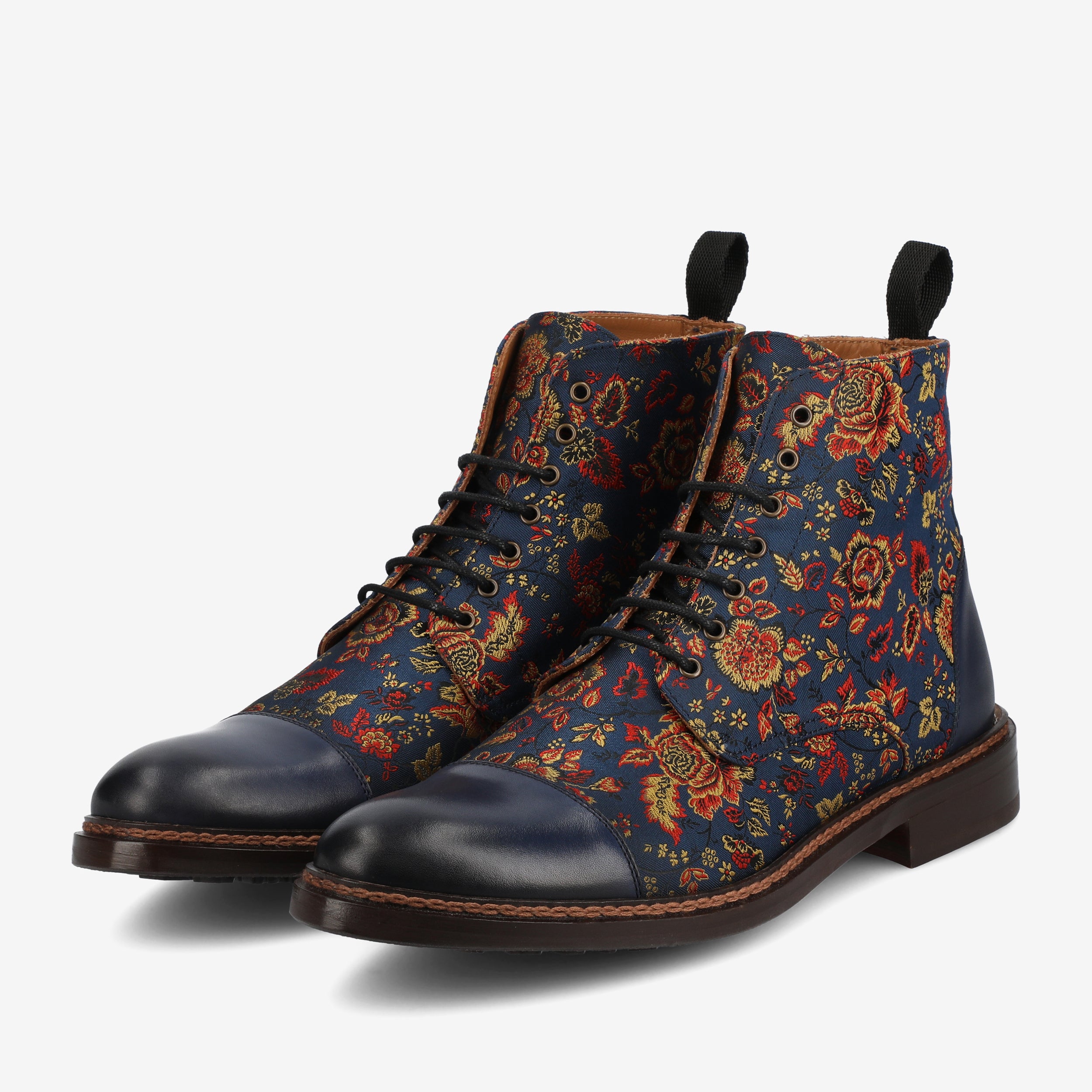 A pair of lace-up boots with a dark blue leather toe and heel, featuring a vibrant floral pattern on the fabric body.