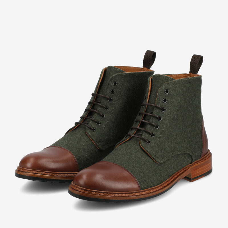 A pair of green fabric and brown leather lace-up boots with brown soles and pull tabs at the back.