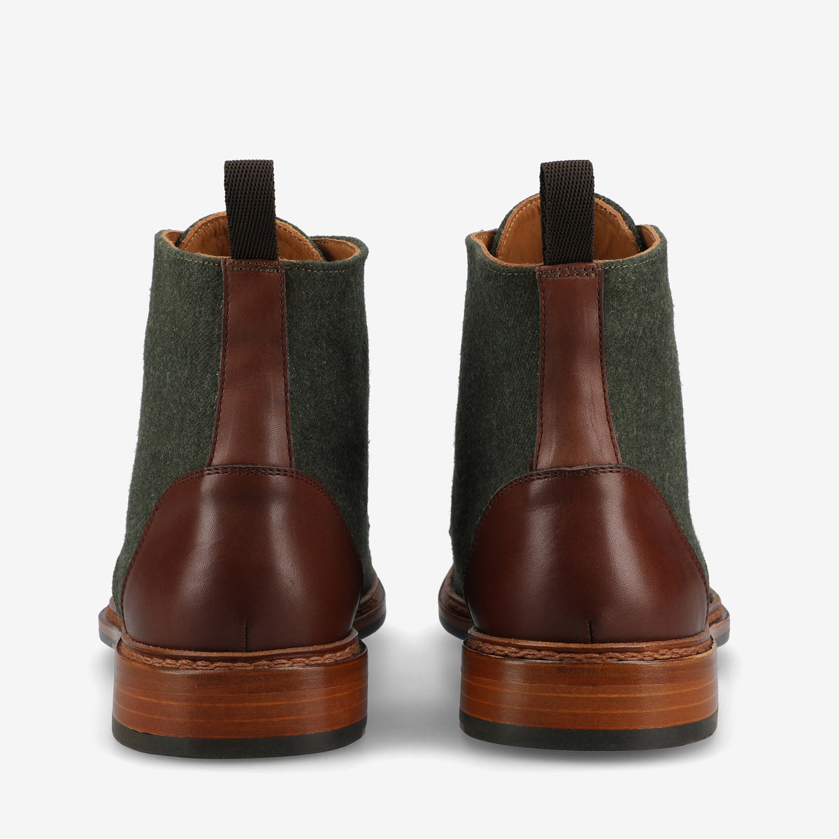 A pair of brown leather and green fabric boots viewed from the back, featuring a wooden sole and pull tabs at the top.