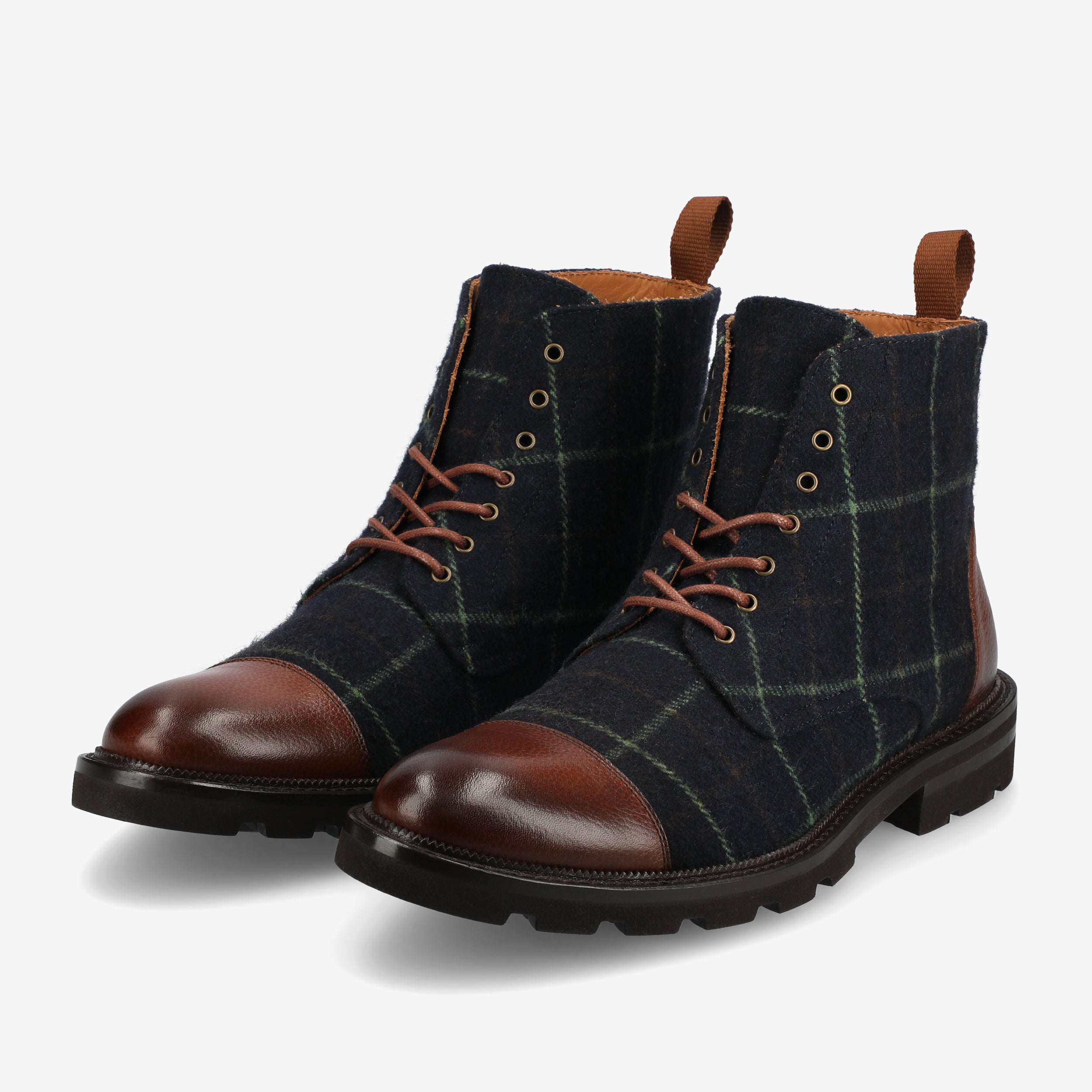 A pair of dark plaid boots with brown leather toes and laces, placed side by side on a light background.