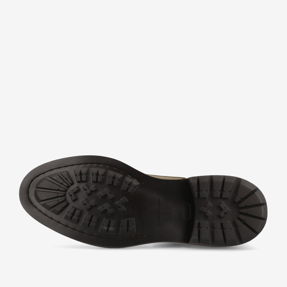 The image displays the bottom of a black, heavy-tread shoe sole, showing various geometric patterns and deep grooves designed for enhanced traction.