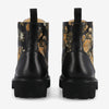 Back view of a pair of black leather boots with a floral print design and thick, grooved soles.