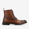 A brown leather lace-up boot with a textured upper and a cap toe, featuring a pull tab, dark laces, and a thick sole.