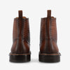 Back view of a pair of brown leather ankle boots with a textured design, showing pull tabs and sturdy soles.