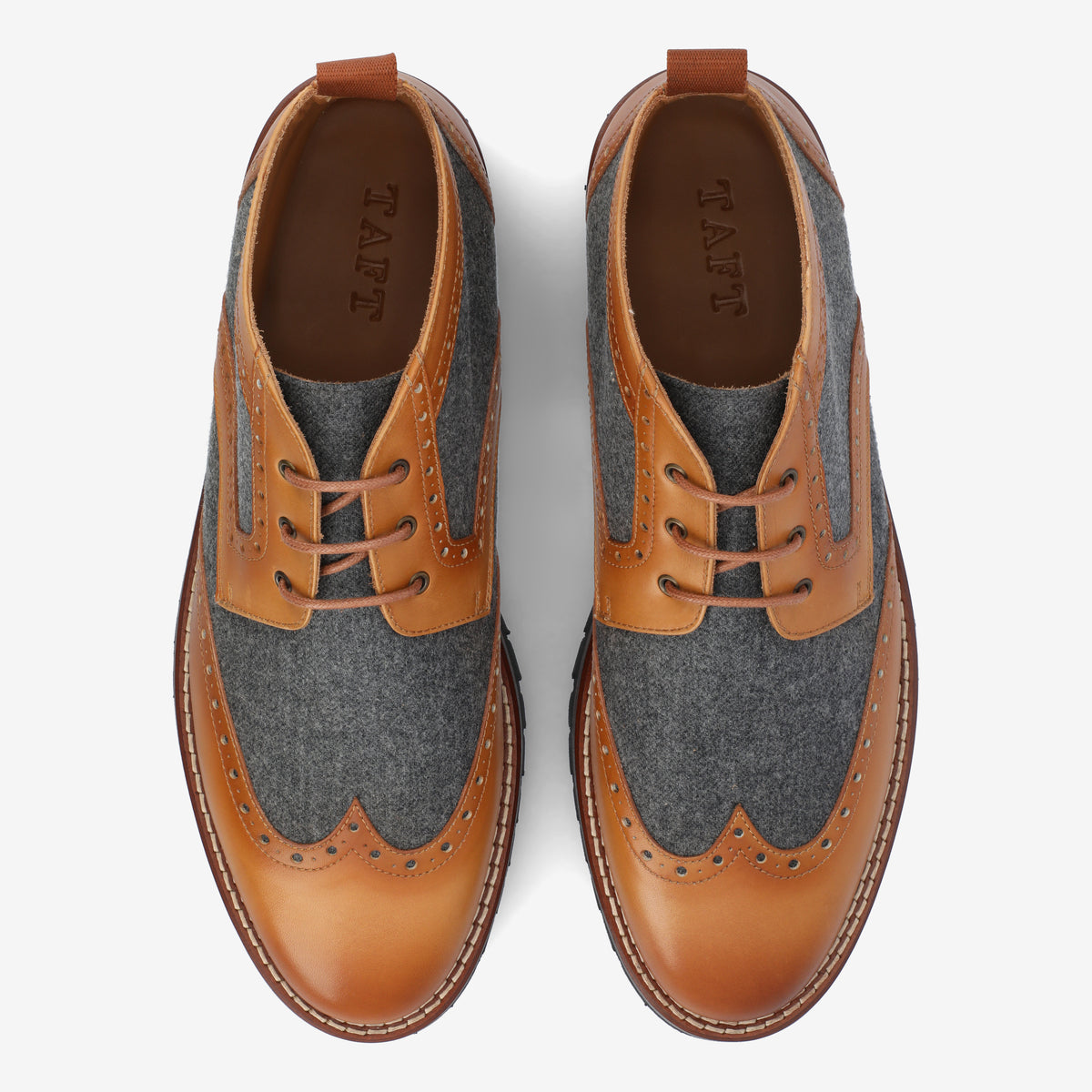 A pair of brogue shoes with brown leather trim and gray fabric panels viewed from above.