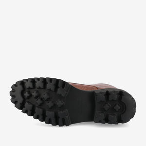 A close-up of a single brown shoe with a black, rugged rubber sole featuring deep treads for enhanced grip and durability.