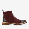 A side view of a burgundy suede ankle boot with black leather toe and heel caps, black laces, and a wooden sole with a grooved tread.