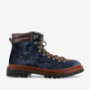 A single navy blue velvet hiking boot with brown leather collar, gold eyelets, and lug sole.