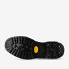 Close-up view of the sole of a black boot with pronounced treads and a yellow Vibram logo.