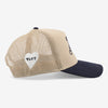 A beige and navy trucker hat featuring a heart-shaped emblem with TAFT on the mesh back.