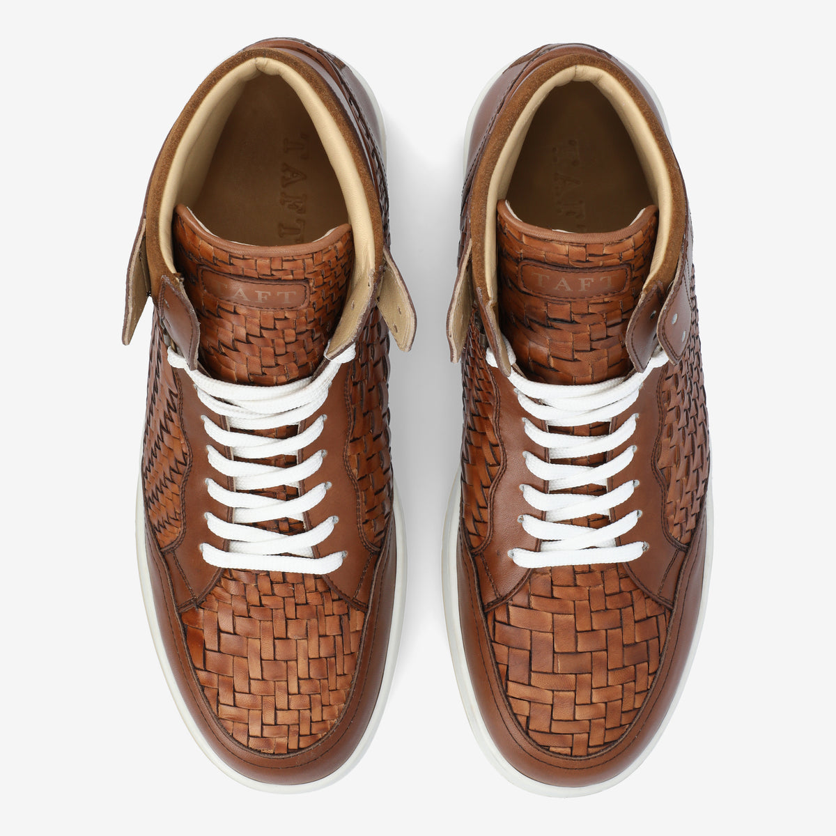 A pair of brown woven leather high-top sneakers with white laces on a white background.