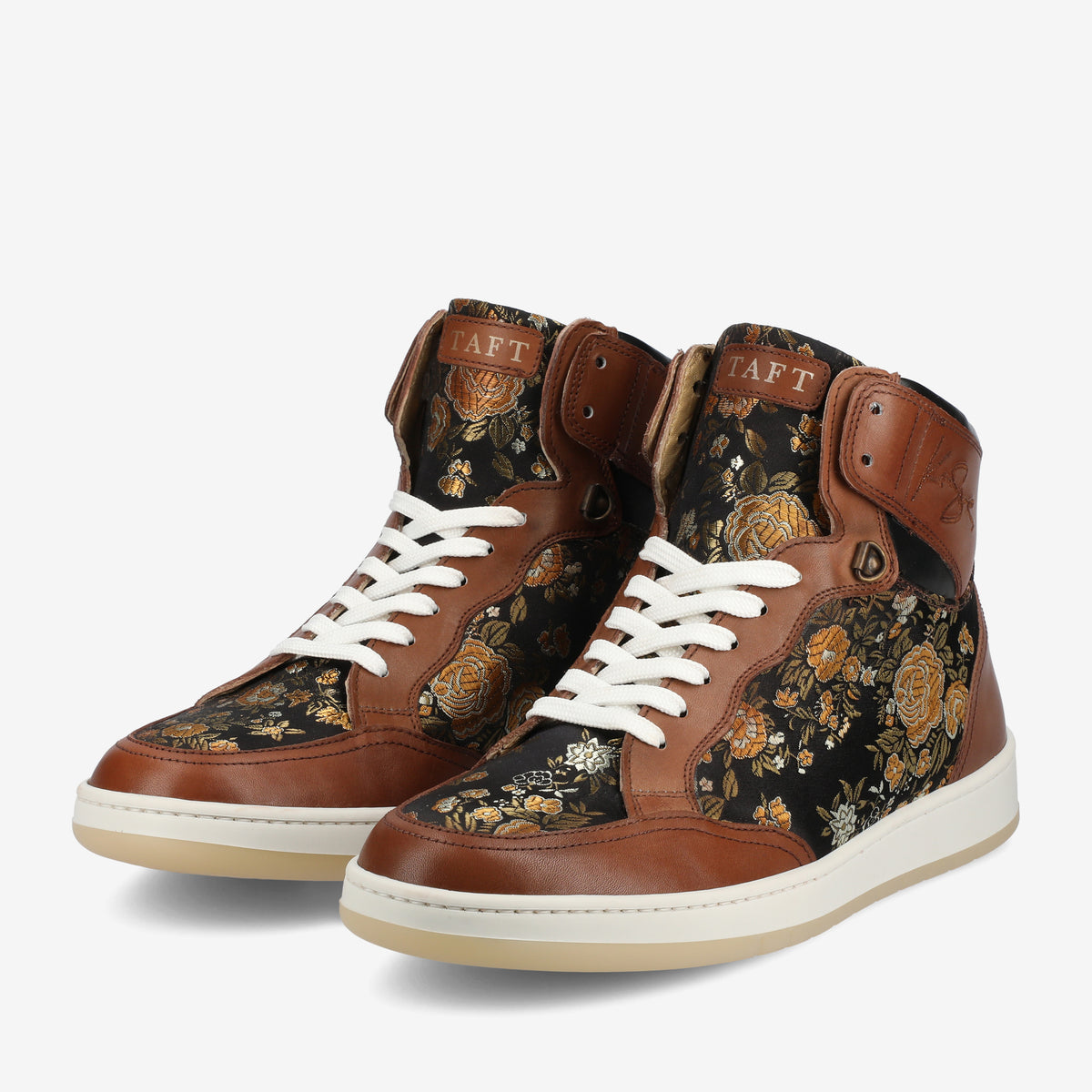 Pair of brown leather high-top sneakers with black and gold floral pattern fabric, white laces, and white rubber soles on a white background.