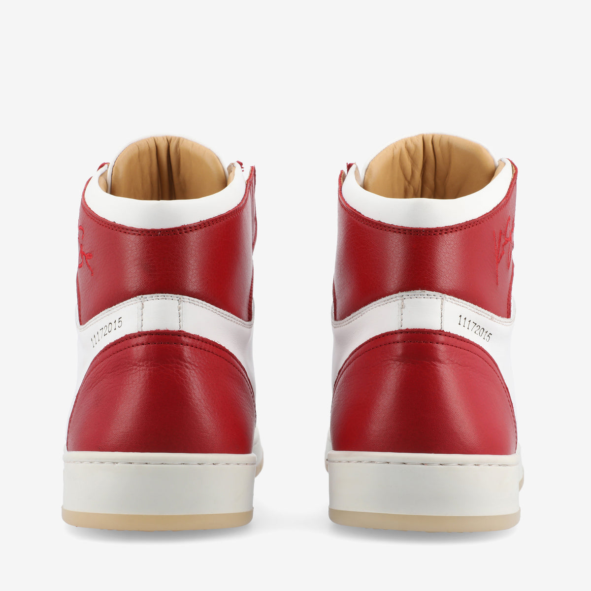 A pair of red and white high-top sneakers viewed from the back, featuring a tan inner lining and a slight view of the soles.