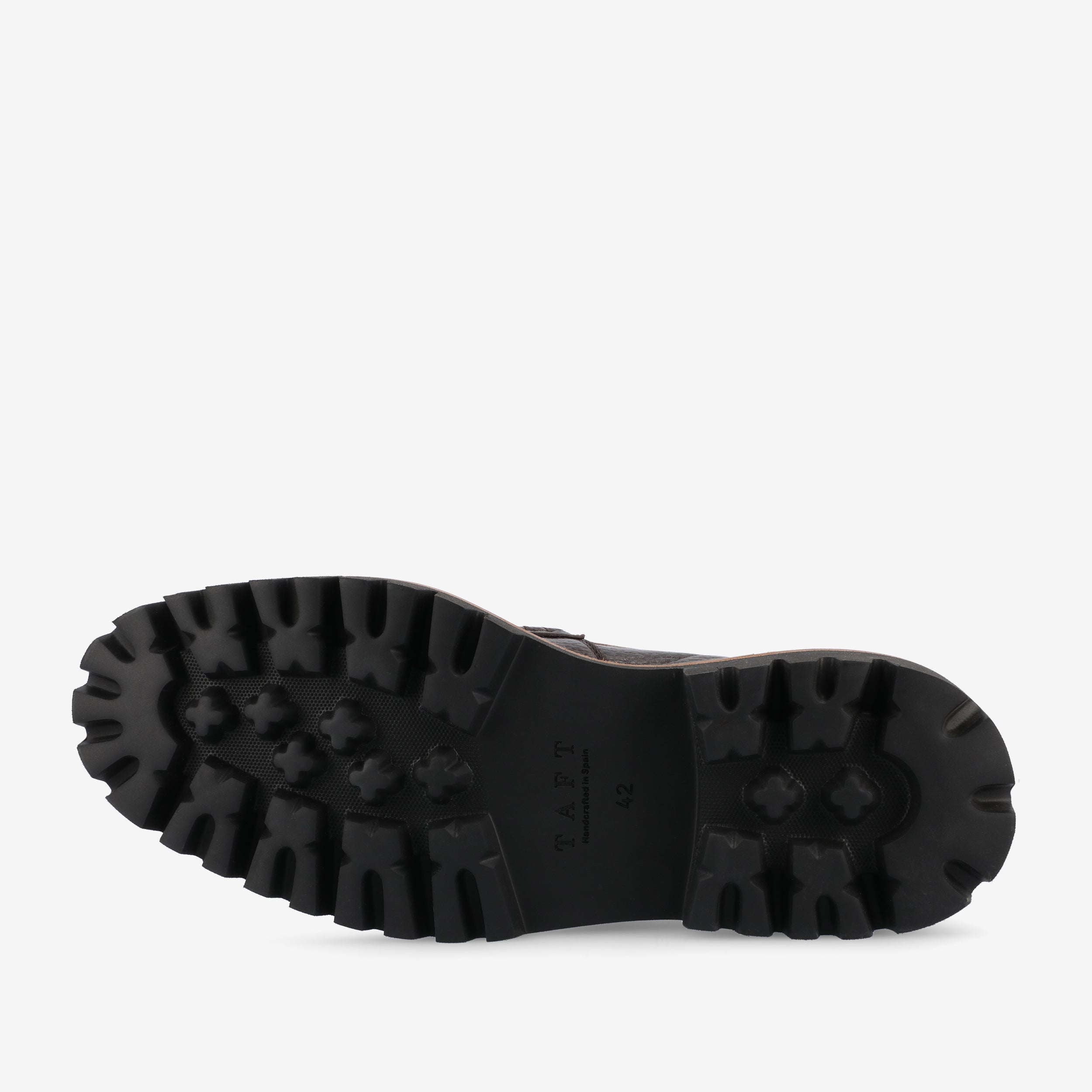 A black shoe sole with a rugged tread pattern and textured surface. The brand name TAFT is engraved on the arch area.