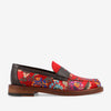 A colorful loafer featuring a red base with a floral pattern, brown leather trim, and a wooden sole.