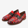 A pair of red loafers with a floral pattern, featuring black leather straps and wooden soles.