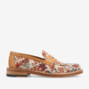 A single loafer with a multicolor floral pattern on the fabric upper, a tan leather trim, and a wooden sole photographed from a side angle.