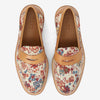 Top view of a pair of loafers with a floral tapestry and tan leather accents. The brand name TAFT is printed inside the shoes.