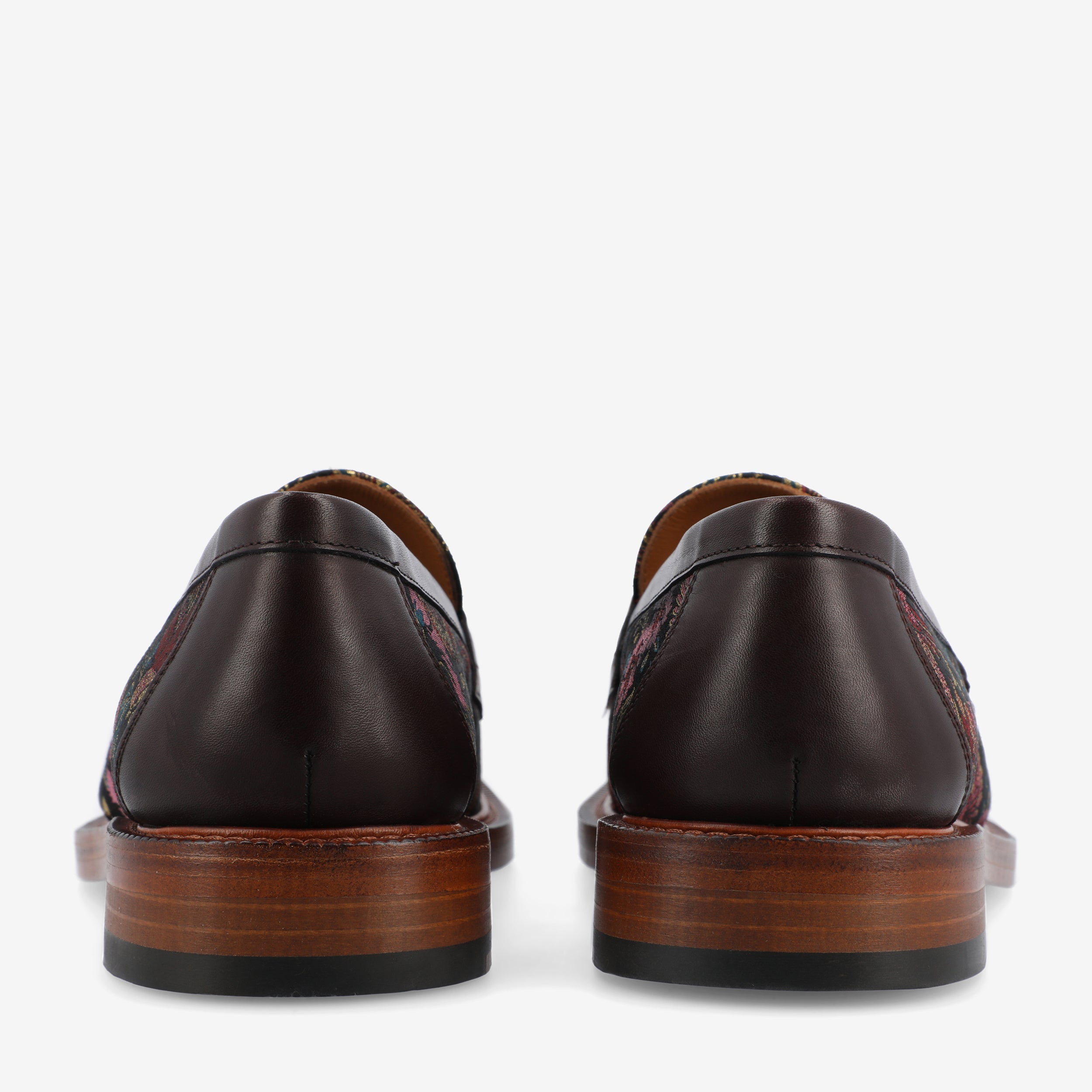 Rear view of a pair of dark brown leather loafers with a wooden sole and a black heel, shown against a white background.