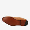 Bottom view of a tan leather shoe with embossed patterns and a partially black heel. The sole is stamped with the word TAFT.