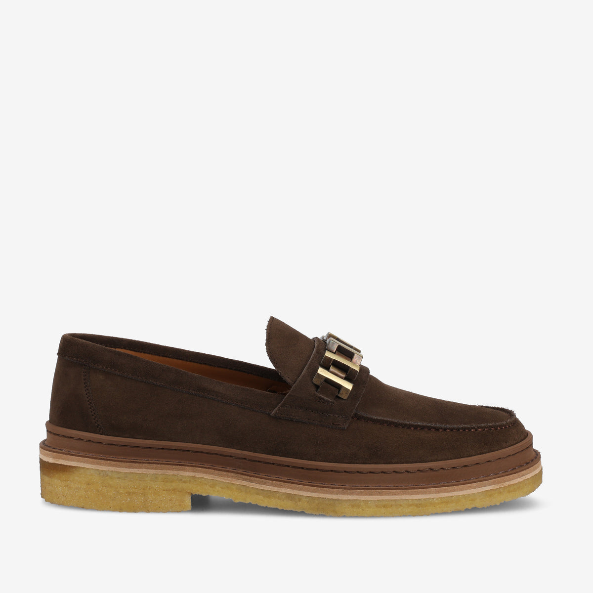 A brown suede slip-on loafer with dual buckle accents and a beige rubber sole.