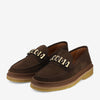 A pair of brown suede loafers with thick soles and metallic chain details on the vamp.