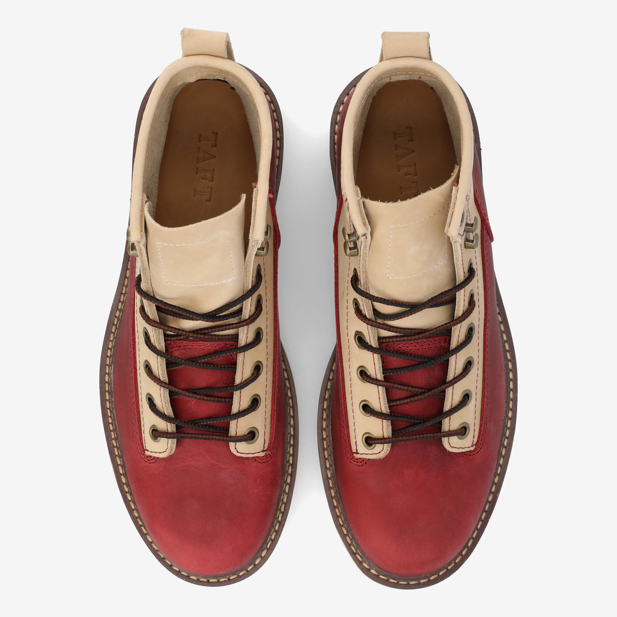 Top view of a pair of red and beige leather lace-up boots with dark brown laces and visible stitching.